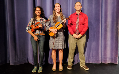 two students with violin and viola standing with director