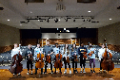 students holding orchestra instruments