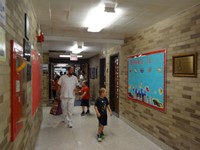 Parents and students walking down hallway.