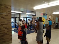 Principal greeting students on first day of school.