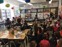 Students reading with Football players