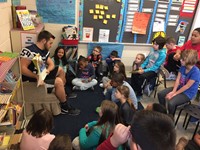 Students reading with Football players