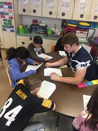 Students reading with Football players