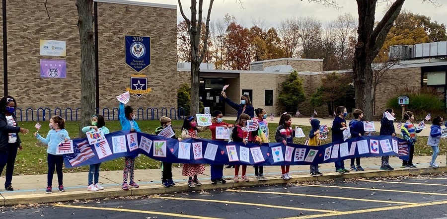 students outside participating in drive by parade to thank veterans