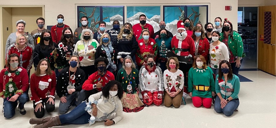 staff dressed in ugly Christmas sweaters
