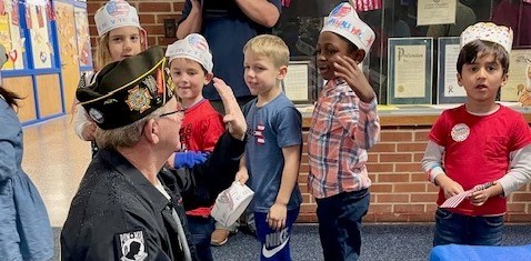 students greeting veteran
