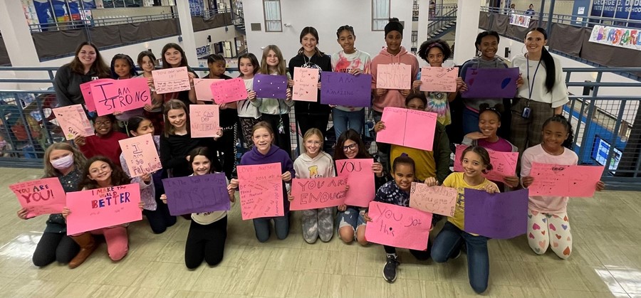 girls holding signs