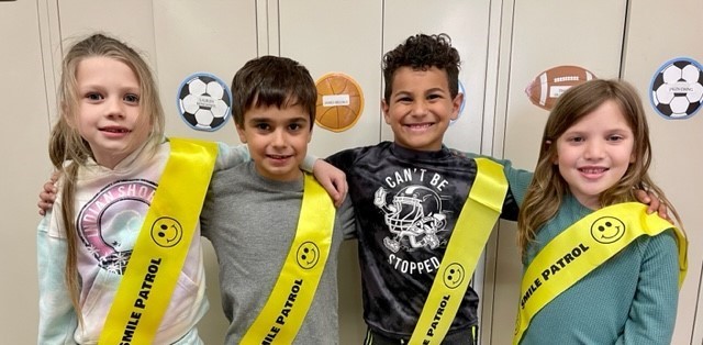students wearing sashes which say smile patrol